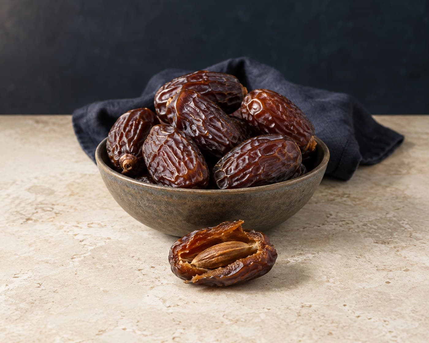Medjool dates with one opened fruit and a visible date pit
